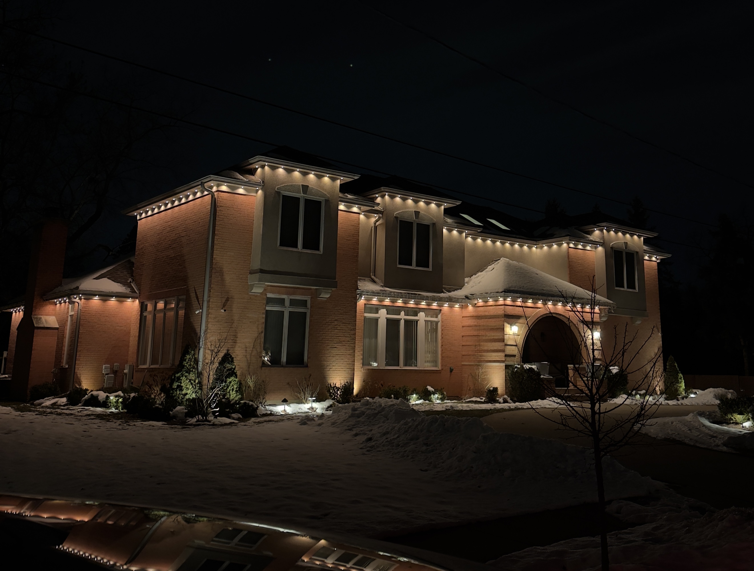 Professional Christmas light installation on luxury home at night — First Frost Palatine IL